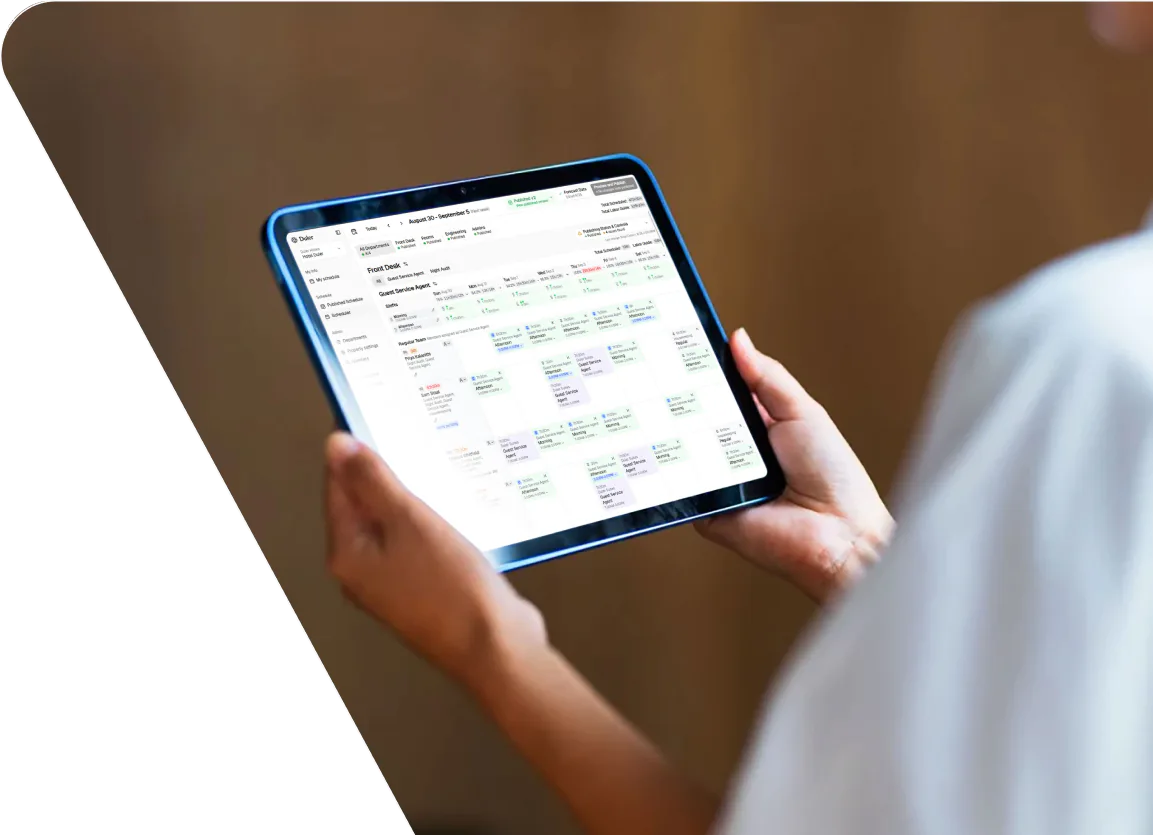 Hotel manager using Duler hotel scheduling software on a tablet